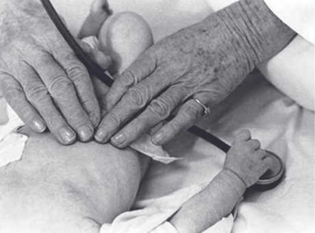 دکتر هلن بروک توسینگ در حال بررسی قلب کودک بیمار با دست هایش